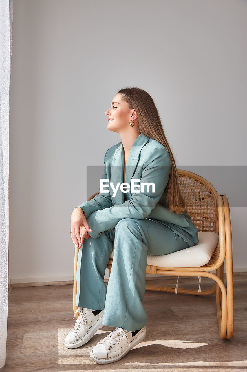 Young woman sitting on chair at home