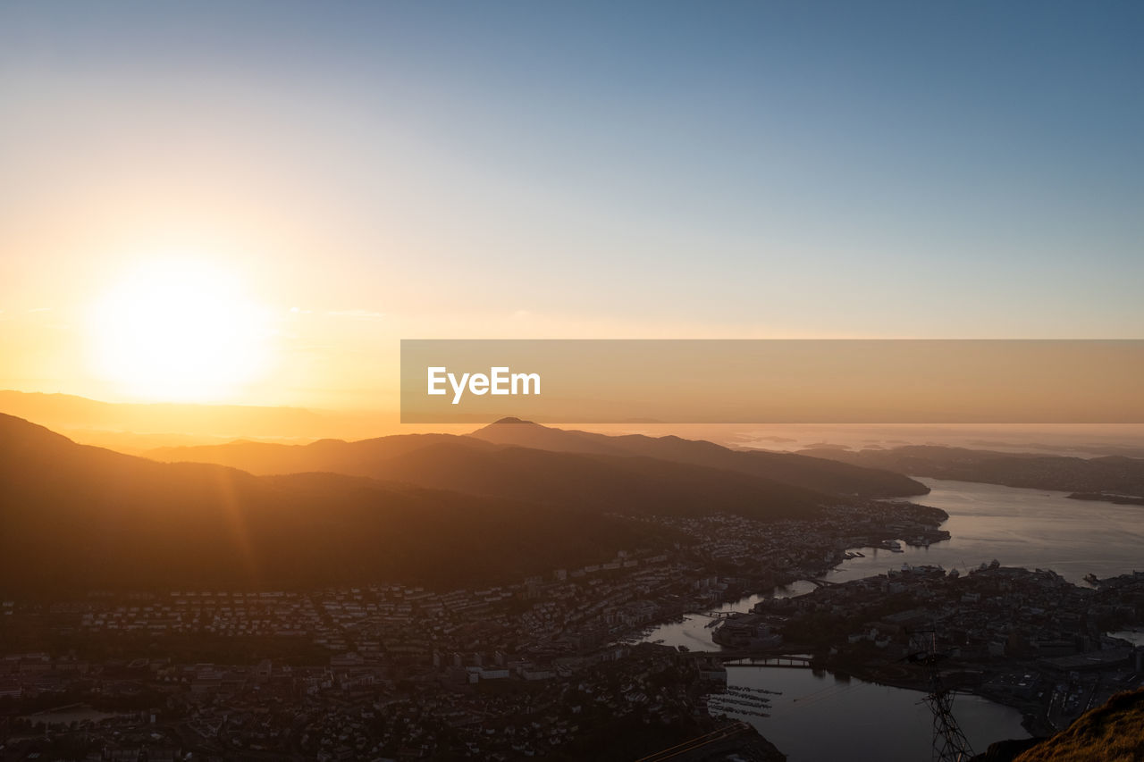 HIGH ANGLE SHOT OF TOWNSCAPE AGAINST SKY DURING SUNSET