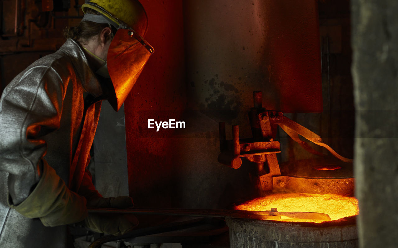 Industry, worker at furnace during melting copper, wearing a fire proximity suit