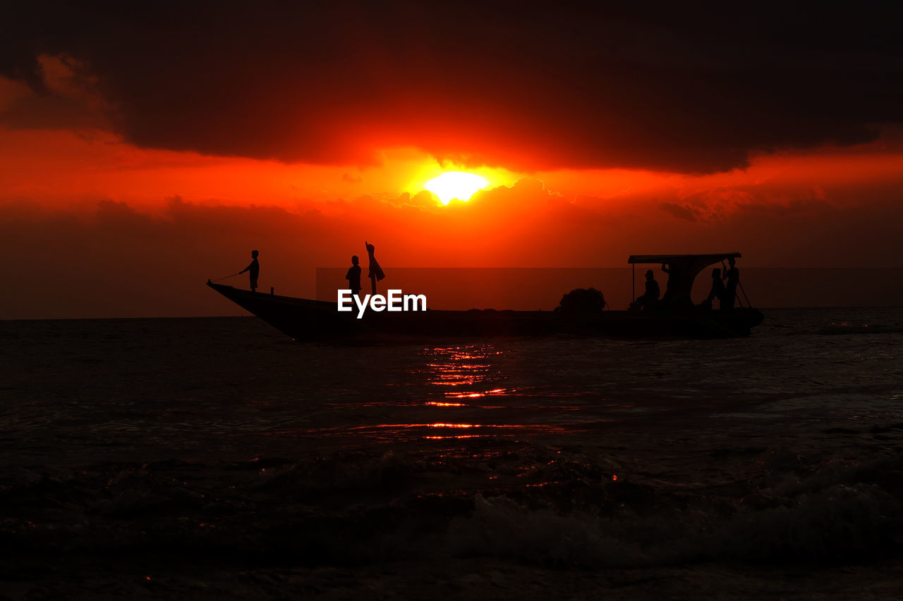 Silhouette of boat in sea during sunset