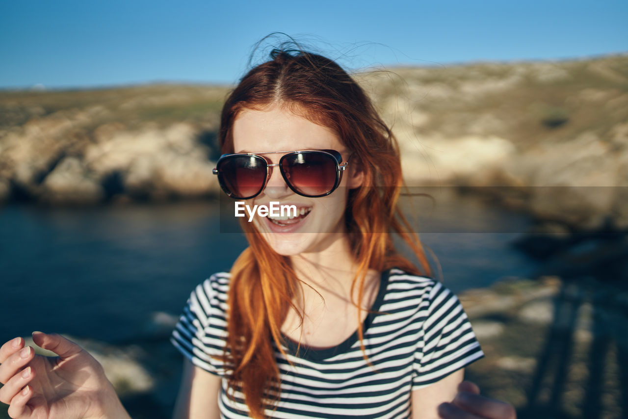 Portrait of smiling young woman wearing sunglasses