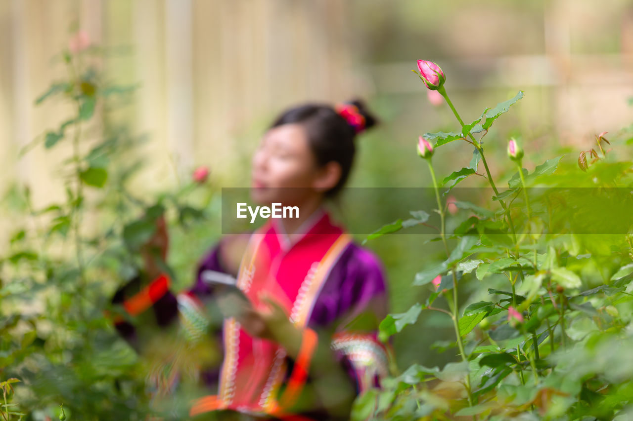 Woman standing by flowering plant