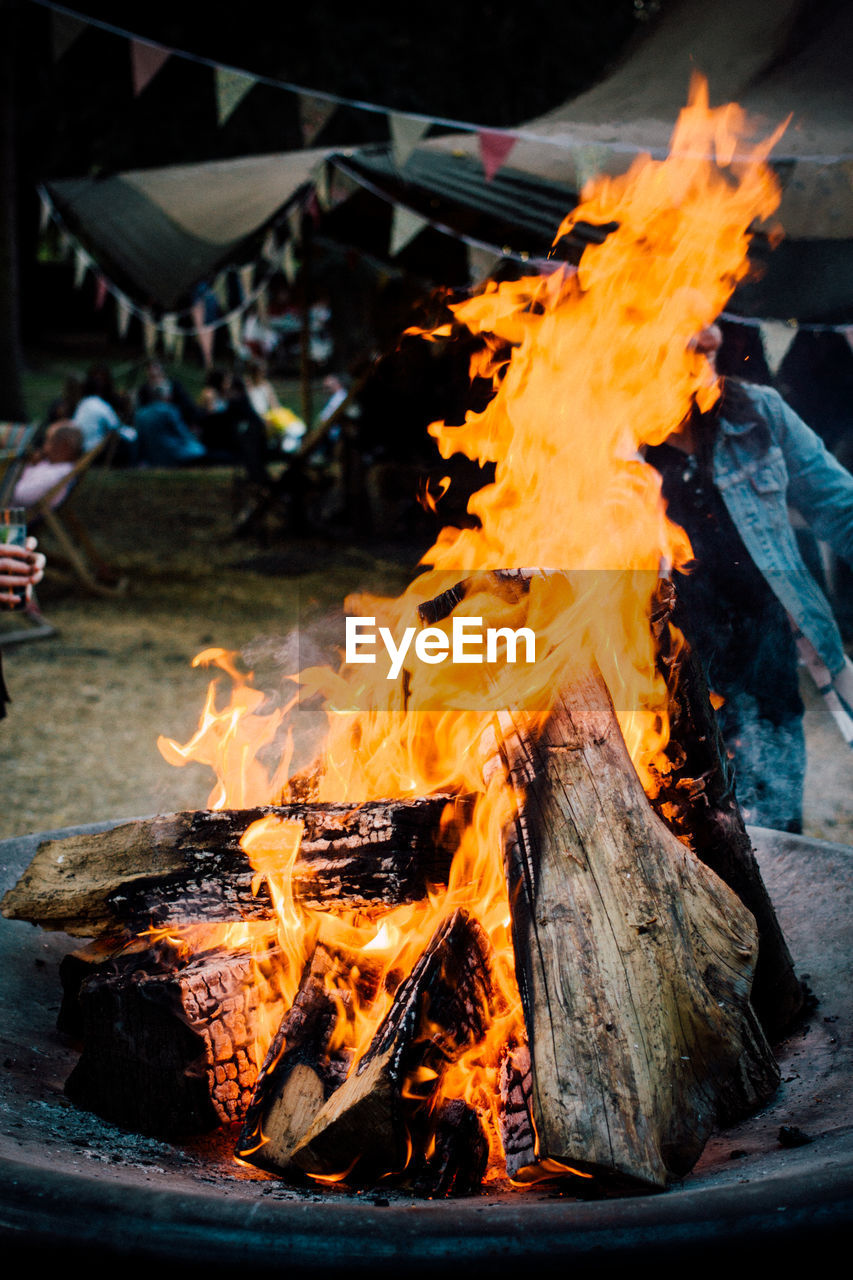 Firewood burning in fire pit at campfire