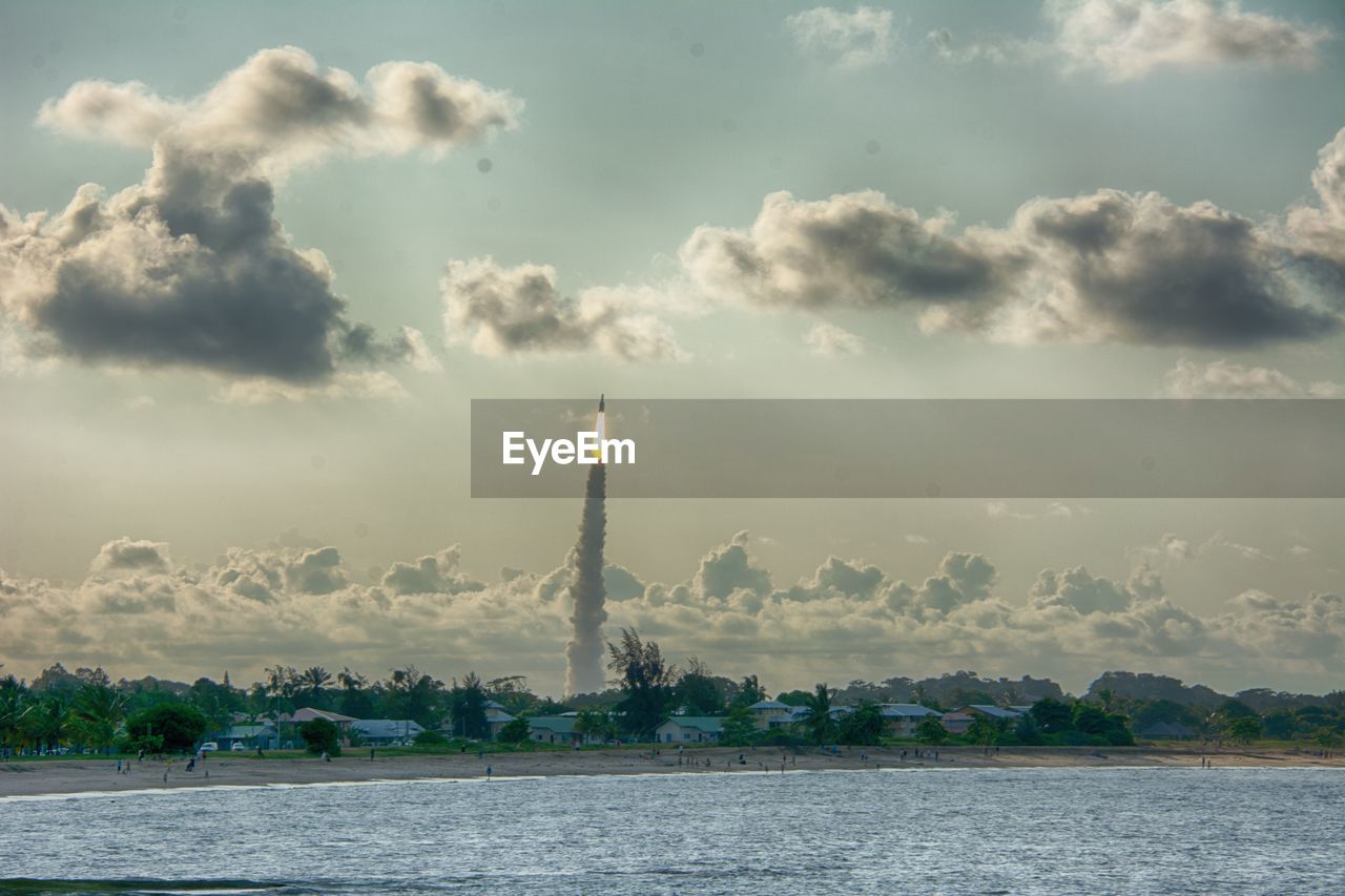 Scenic view of river against cloudy sky