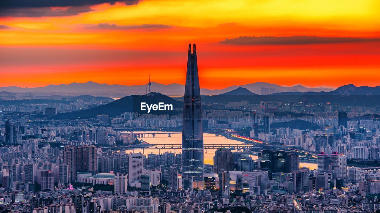 High angle view of city against cloudy sky during sunset