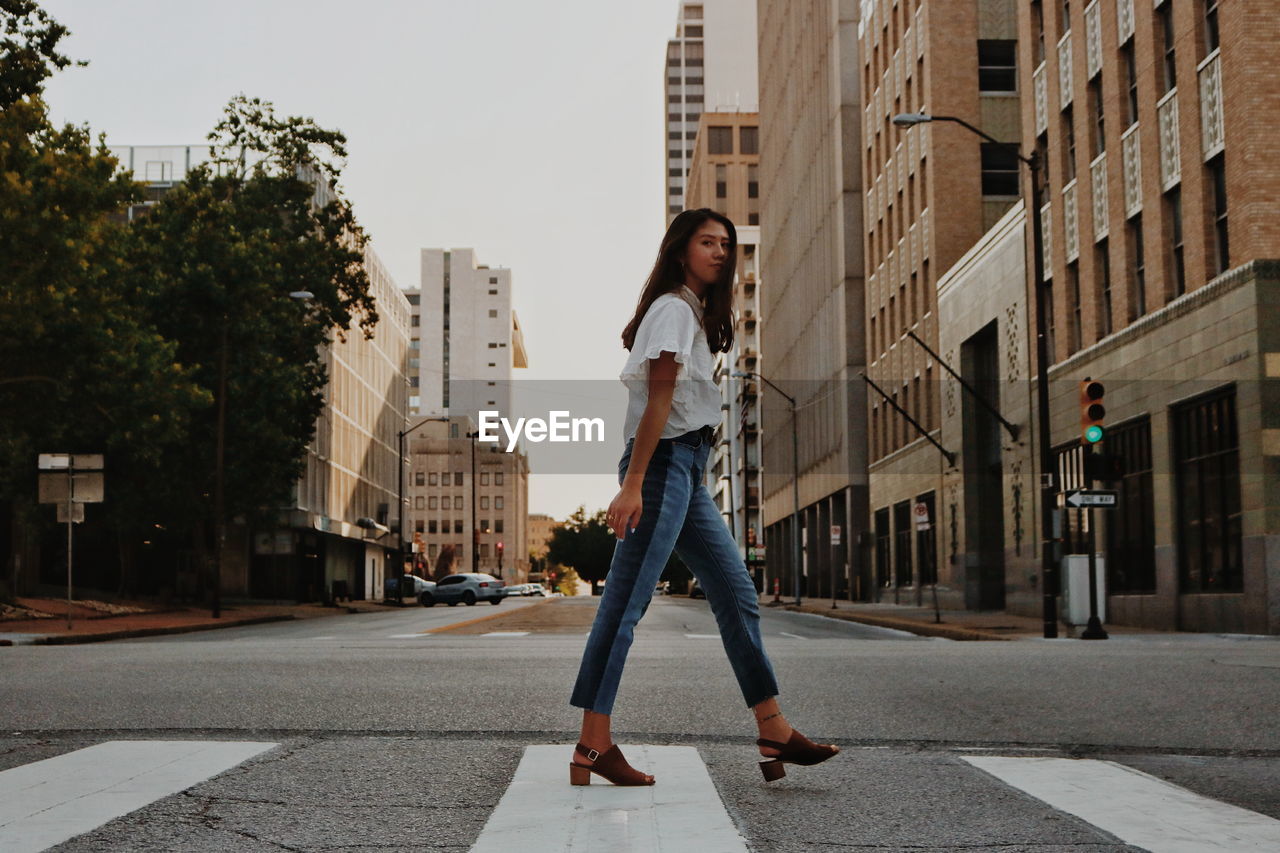 Woman crossing street in city