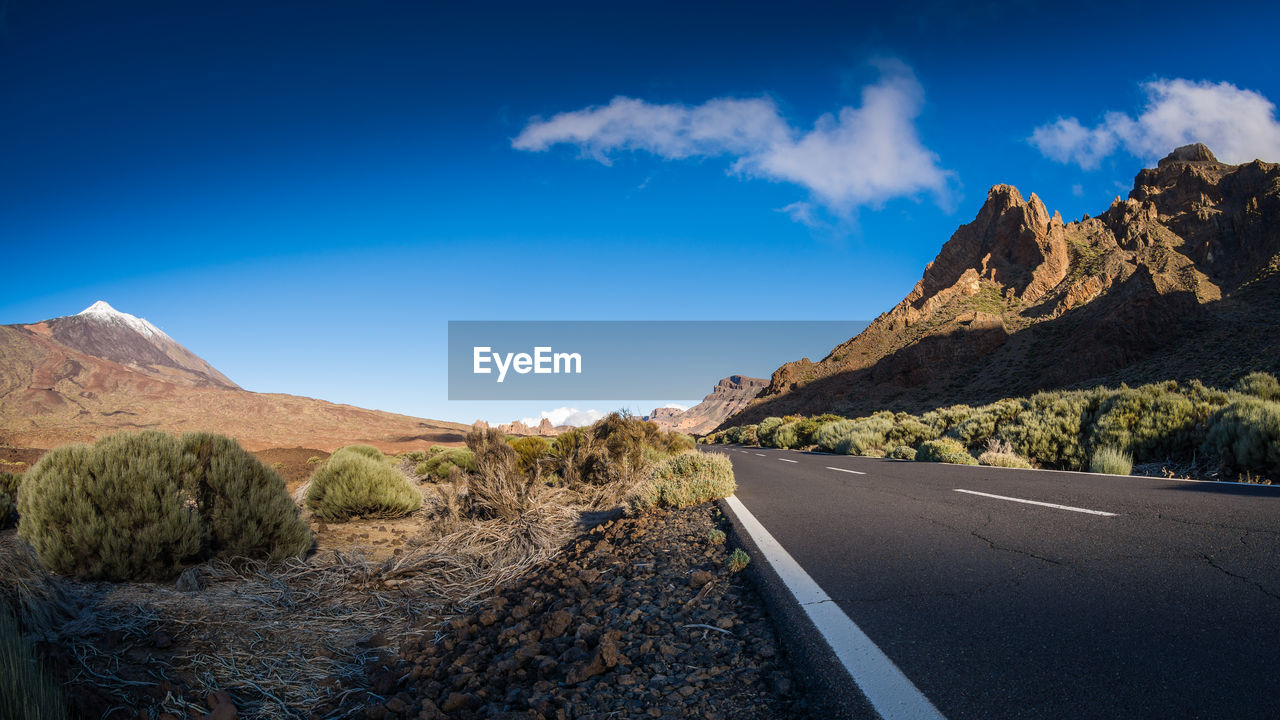 ROAD BY MOUNTAINS AGAINST SKY