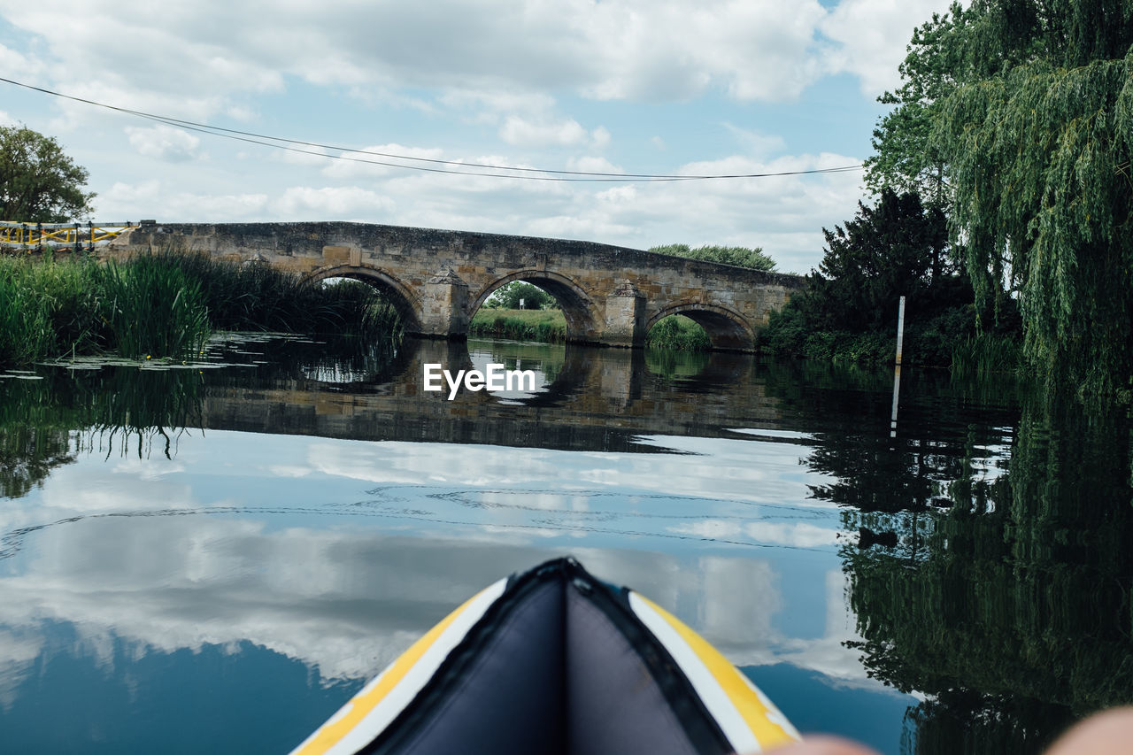 Bridge over river against cloudy sky