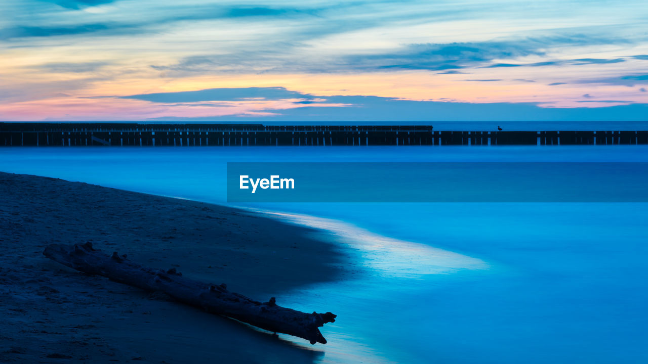 SCENIC VIEW OF SEA AT SUNSET