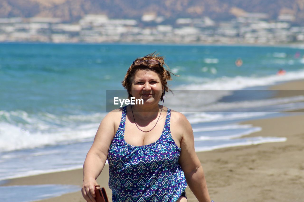 Portrait of smiling curvy woman on beach