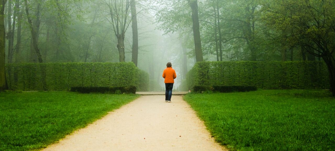 REAR VIEW OF WOMAN WALKING ON ROAD