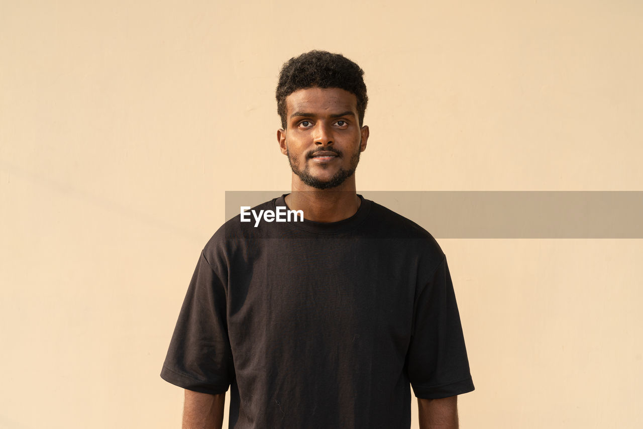 Portrait of handsome young african man wearing oversized black t-shirt