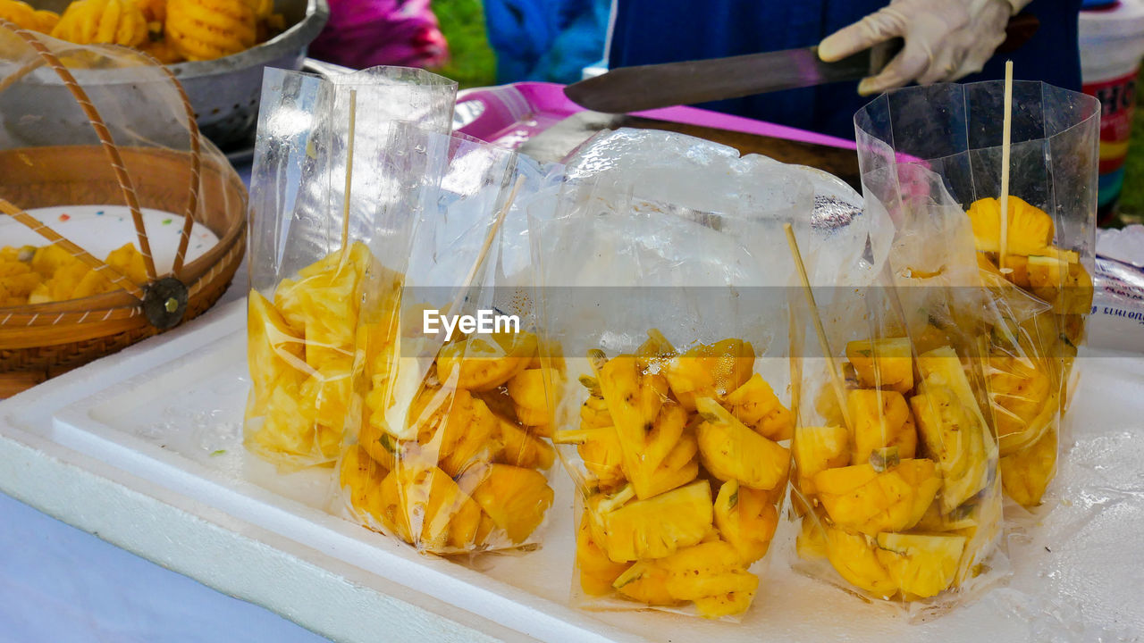 Pineapples in plastic bags for sale at market