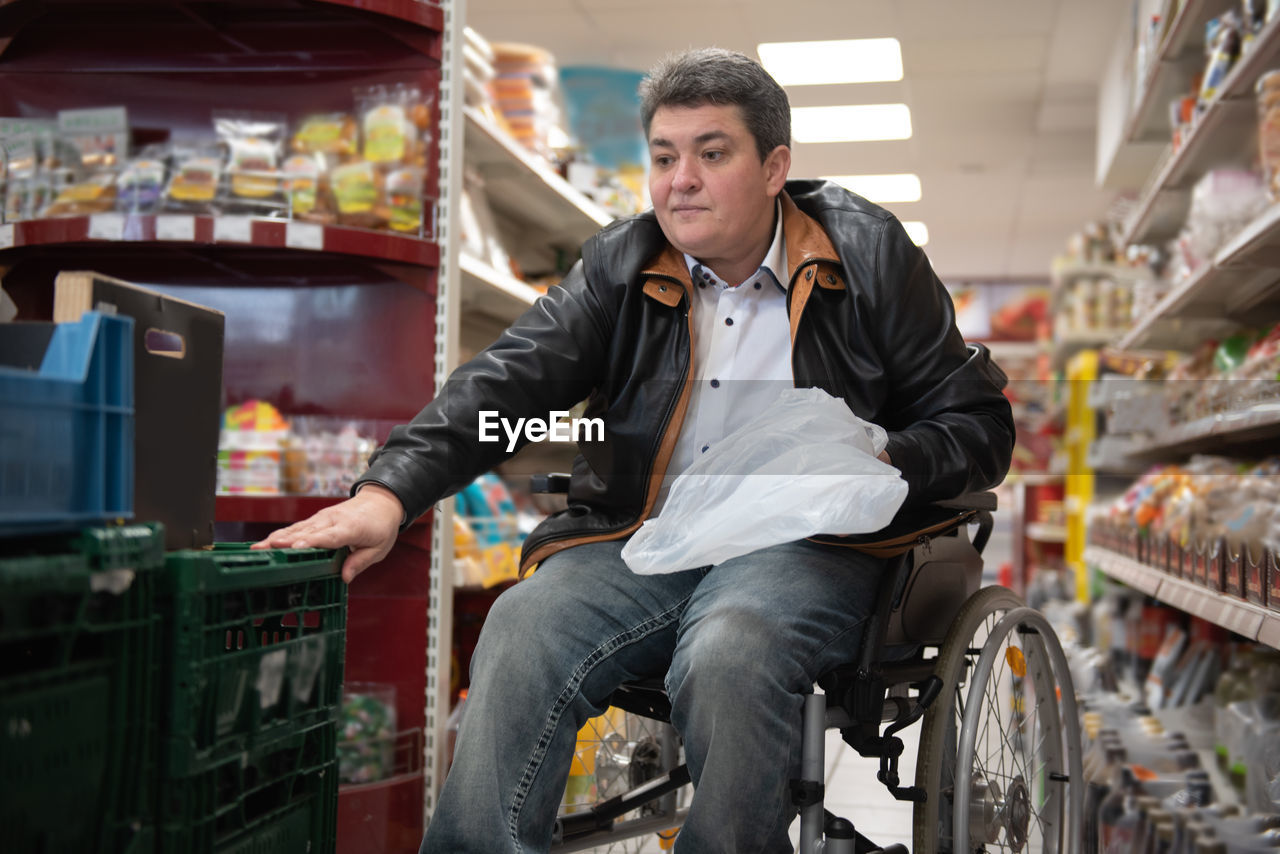 A disabled person in a wheelchair buys groceries