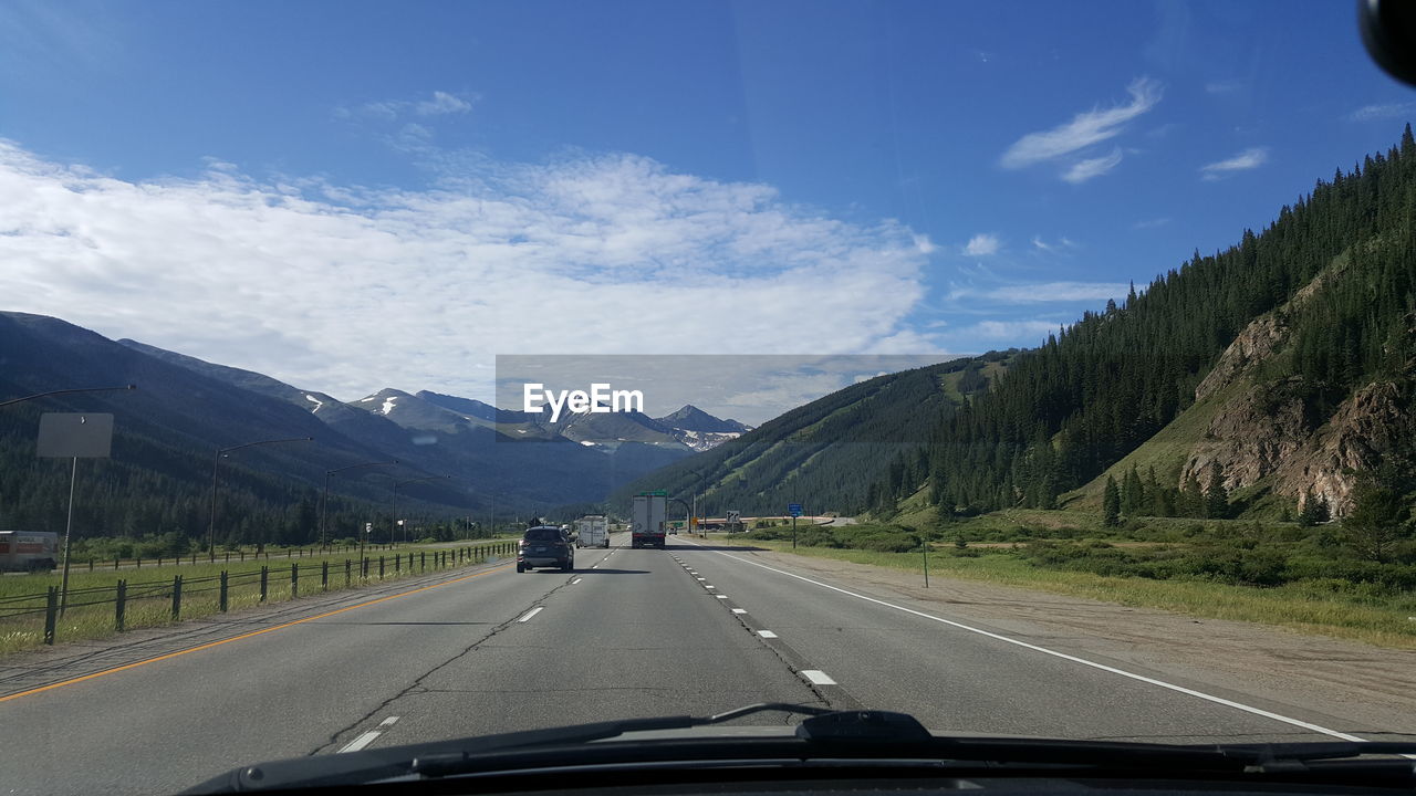 ROAD SEEN THROUGH CAR WINDSHIELD