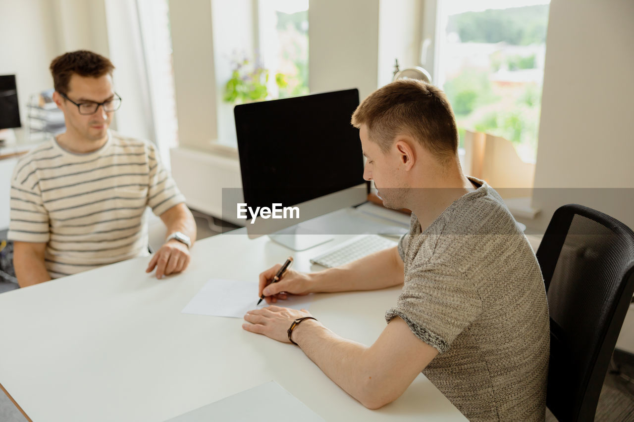 Serious professional man consulting client in office. two mens having meeting