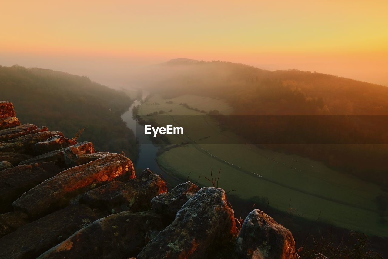 AERIAL VIEW OF MOUNTAIN AGAINST SKY DURING SUNSET