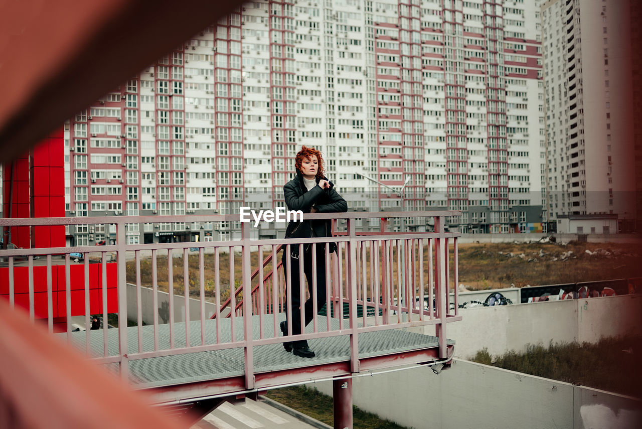 Rear view of woman standing against building