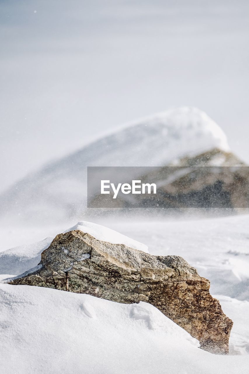 Scenic view of snow covered rock against sky