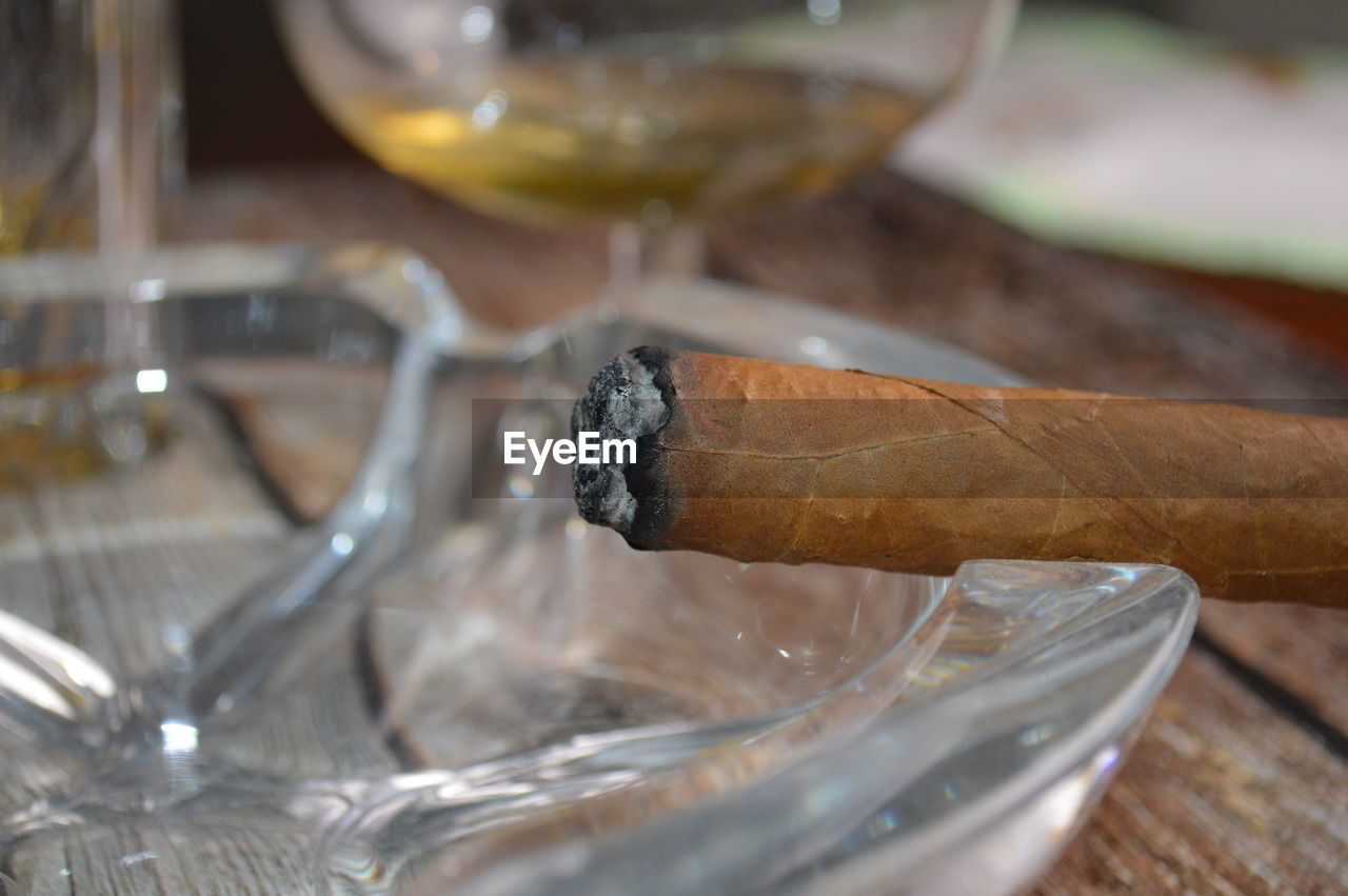 Close-up of cigarette with alcohol on table