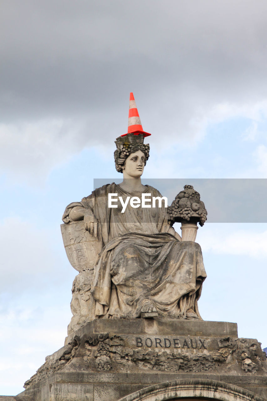 Statue representing bordeaux on the place de la concorde in paris with a traffic cone on the top 