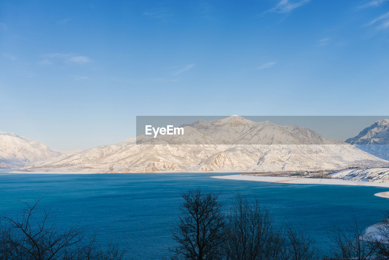 Charvak reservoir with blue water on a clear winter day in uzbekistan