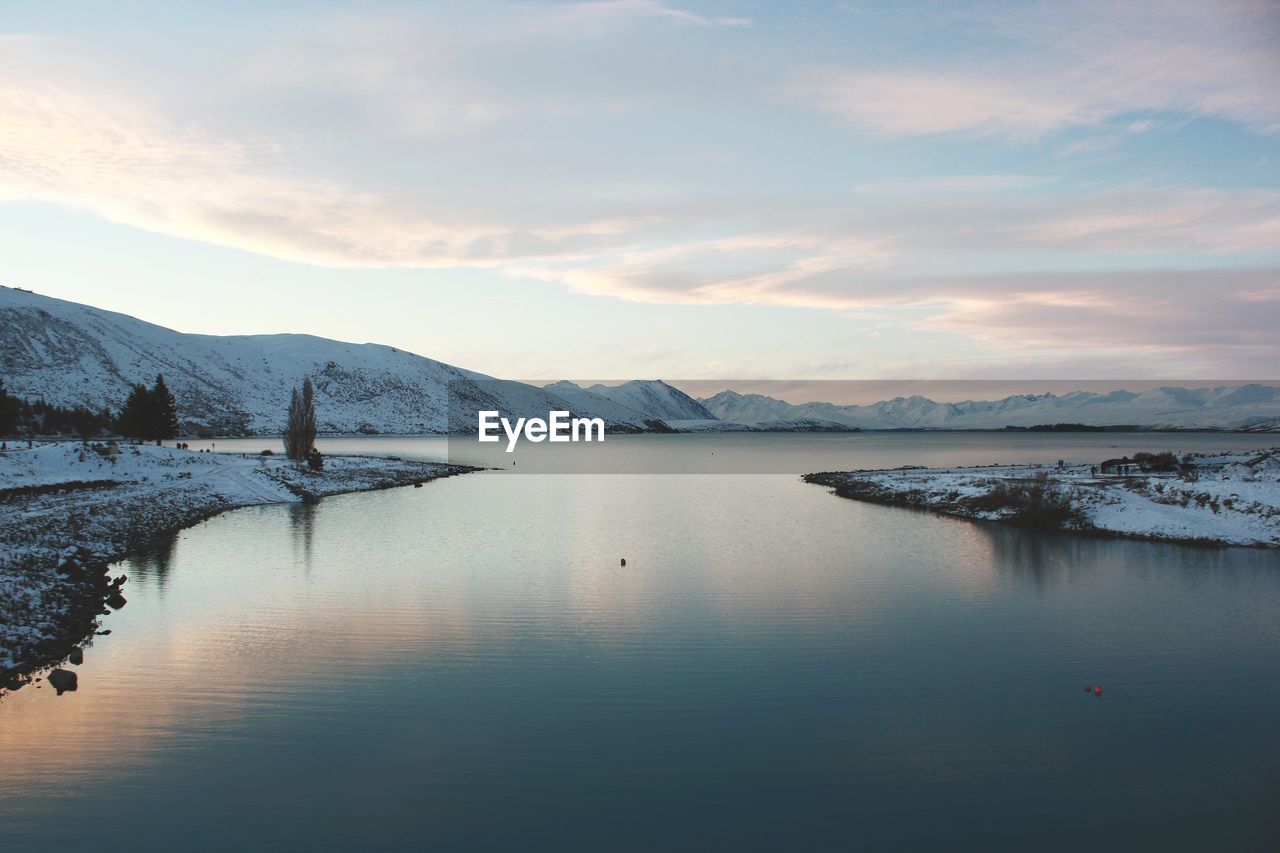 Scenic view of lake against sky during winter