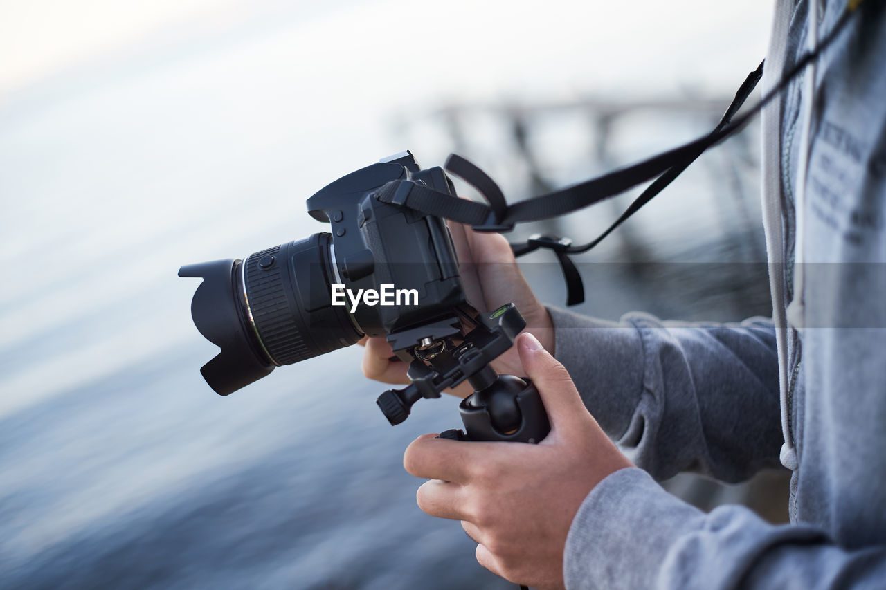Midsection of man holding camera