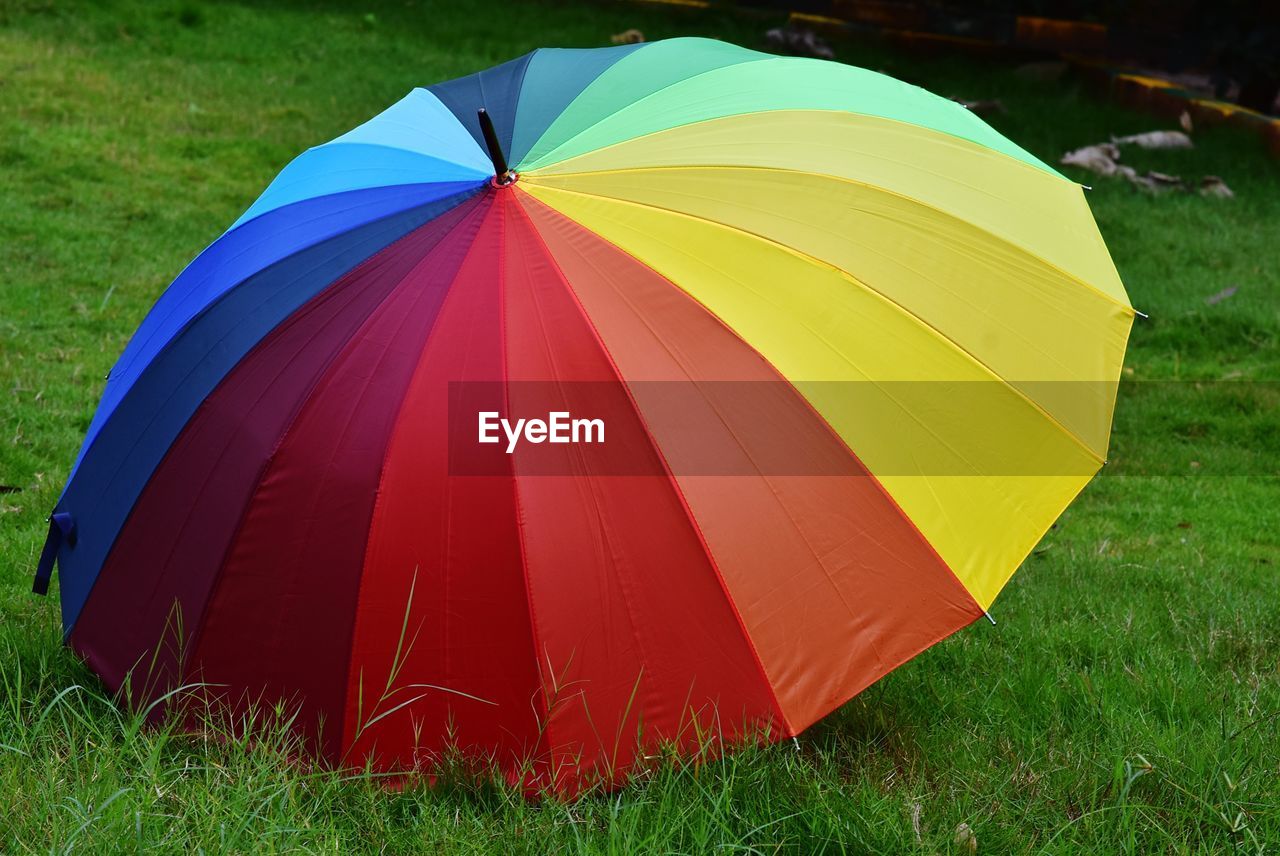 Close-up of multi colored umbrella on field