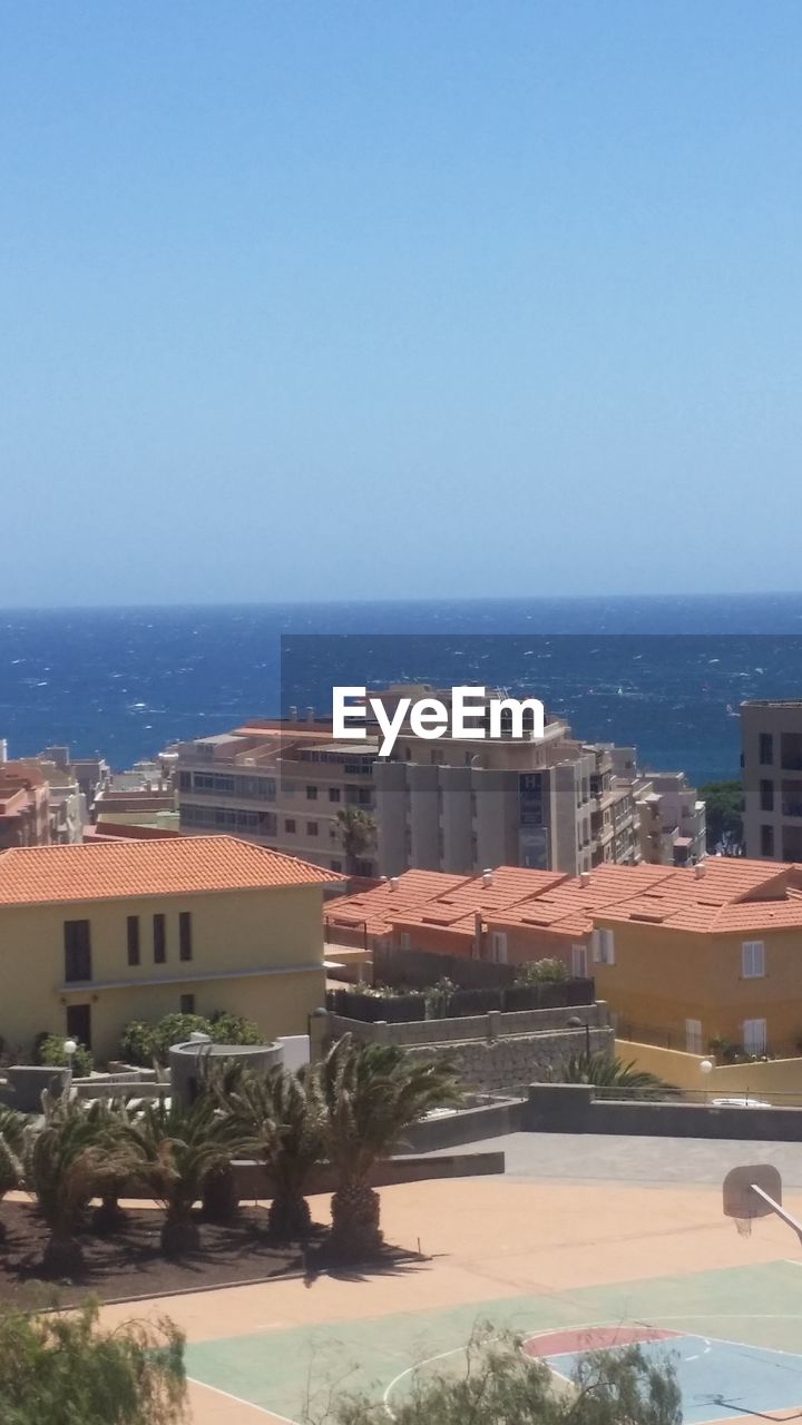 SCENIC VIEW OF SEA BY BUILDINGS AGAINST CLEAR SKY