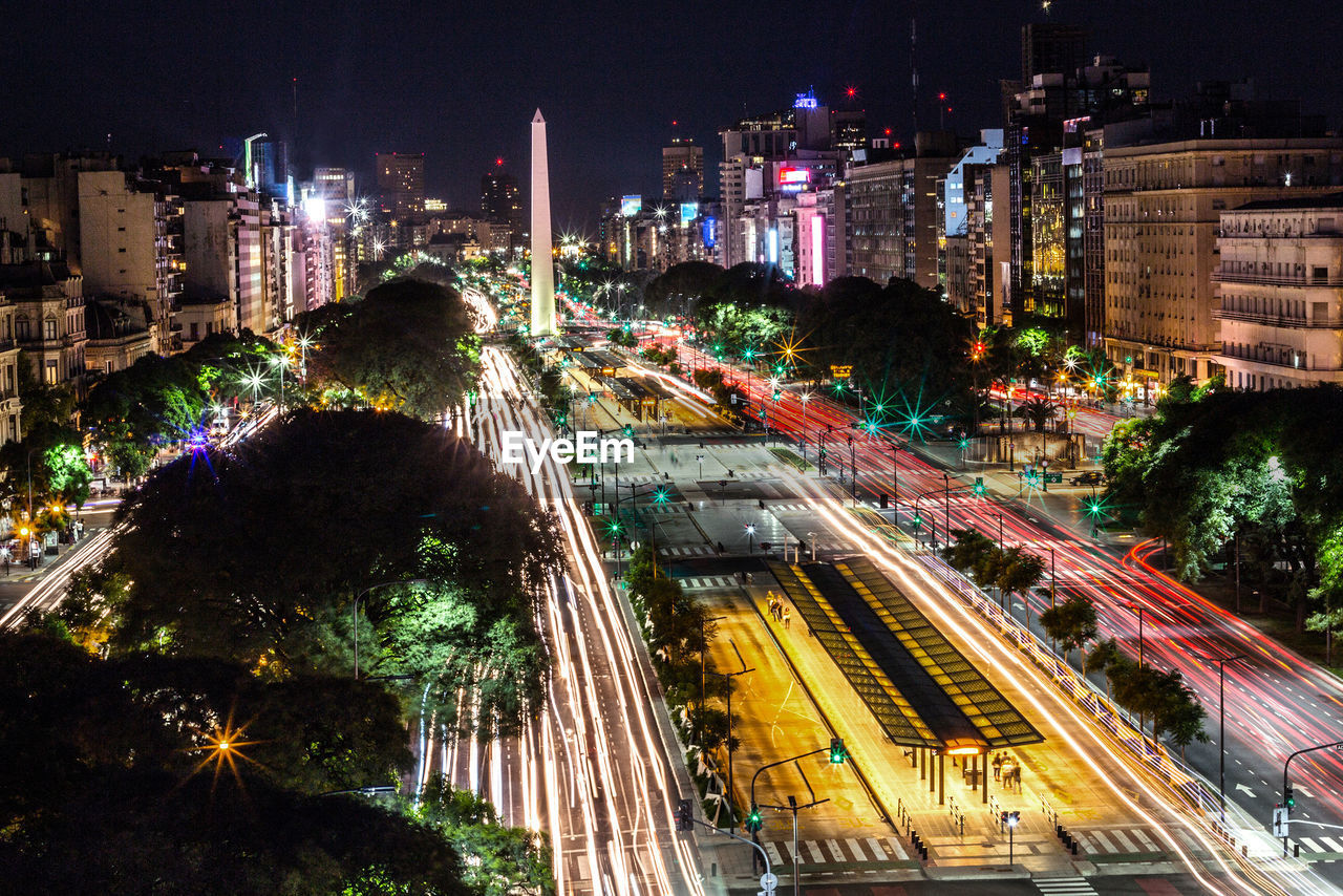 High angle view of light trails on road along buildings