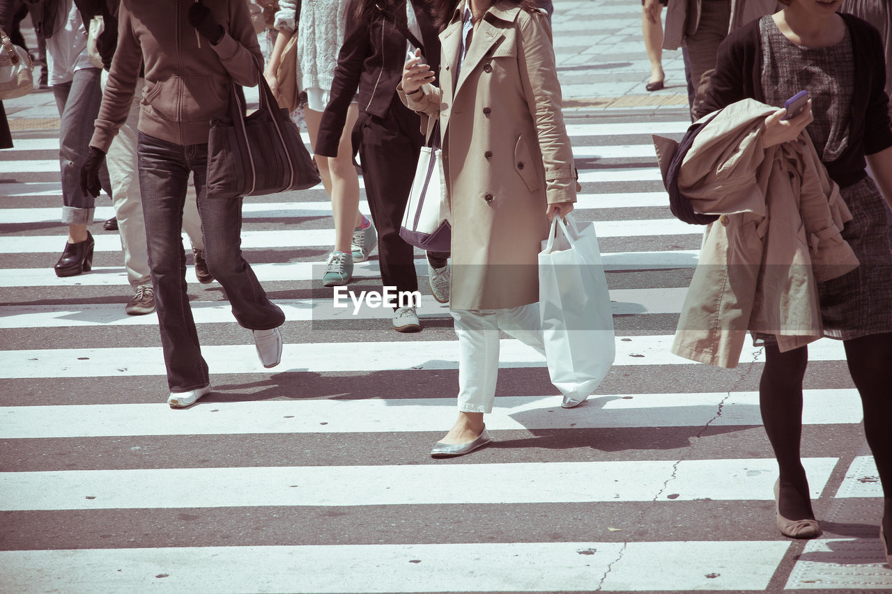 Low section of business people walking on road