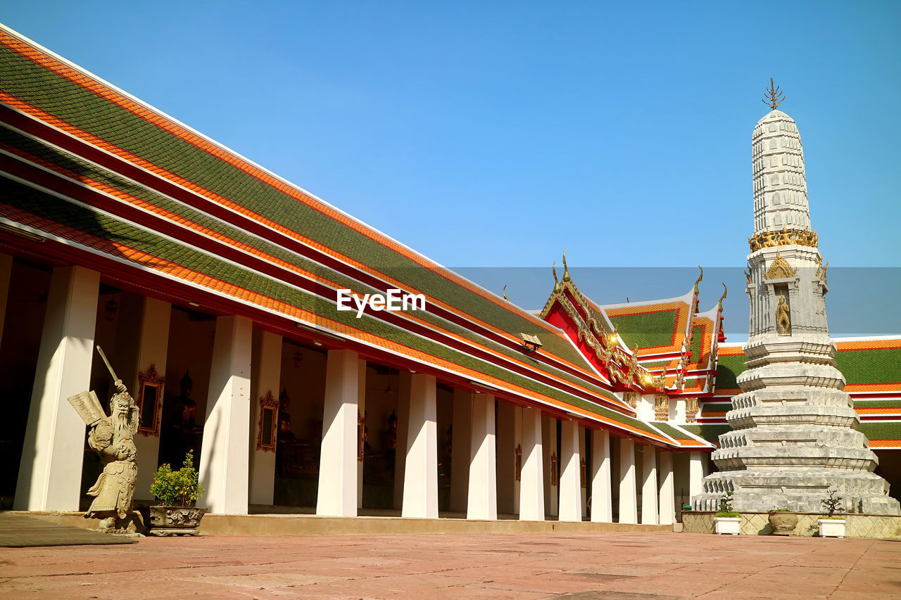 Cloister of wat pho temple with phra prang pagoda and chinese guardian statue, bangkok, thailand