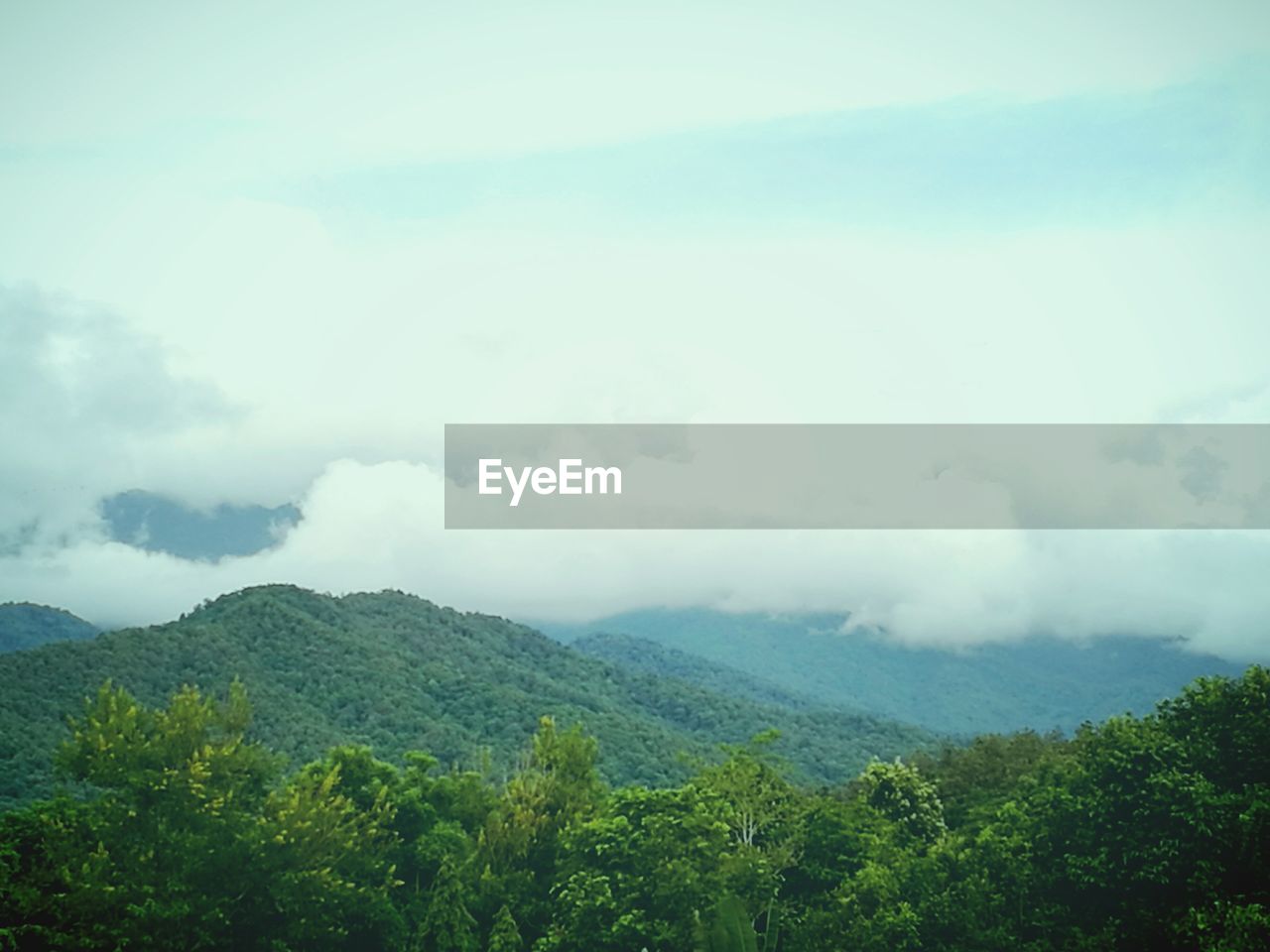 Scenic view of mountains against cloudy sky