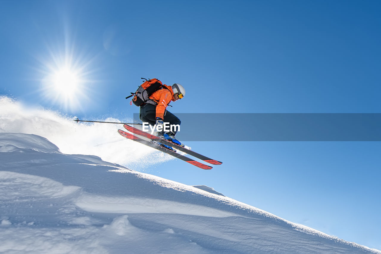 A young skier at speed flying through the sky