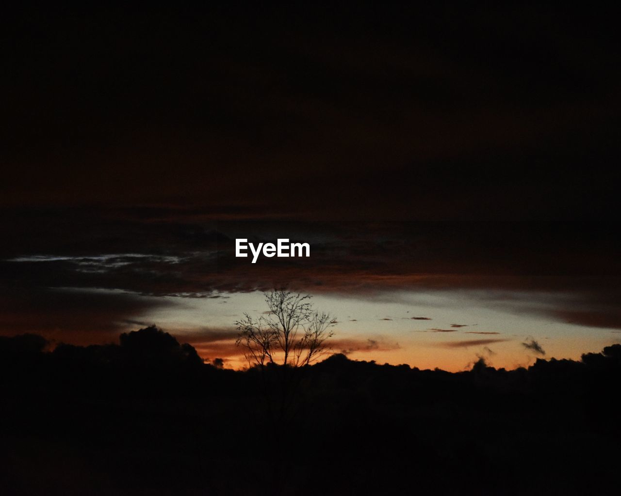 SILHOUETTE LANDSCAPE AGAINST SUNSET SKY