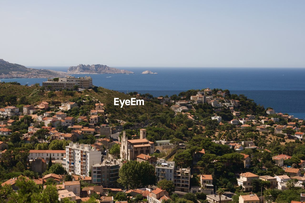 High angle view of townscape by sea against sky