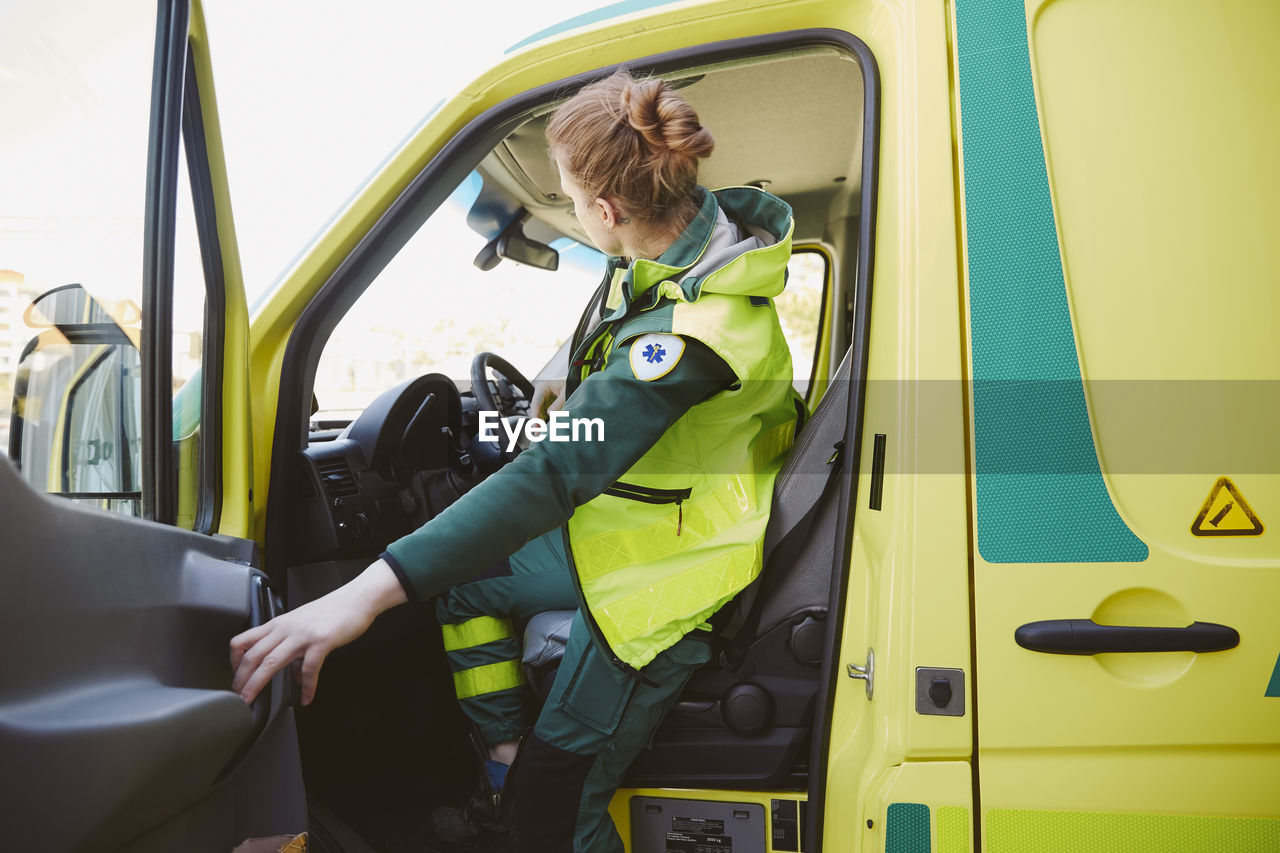 Female paramedic closing door of ambulance
