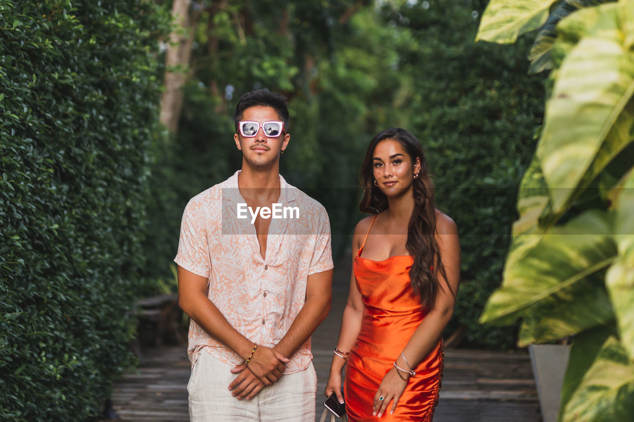 Fashion shot of an attractive young couple in summer clothes posing outdoor