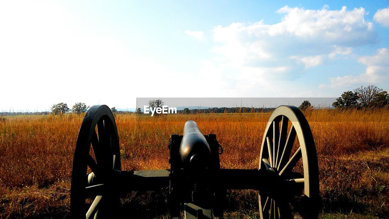 Cannon on grassy field against sky