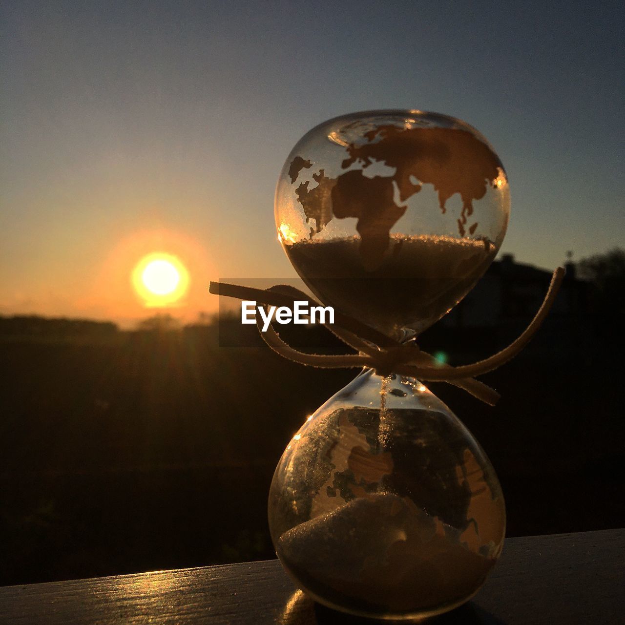 CLOSE-UP OF CRYSTAL BALL ON TABLE AGAINST SUNSET