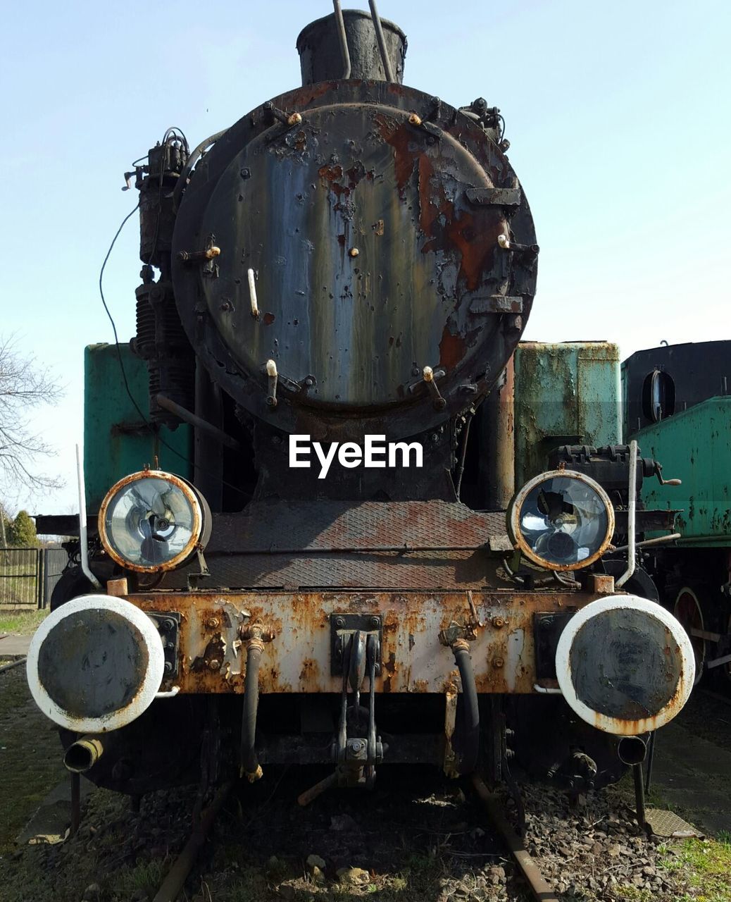 Old train parked on field against sky