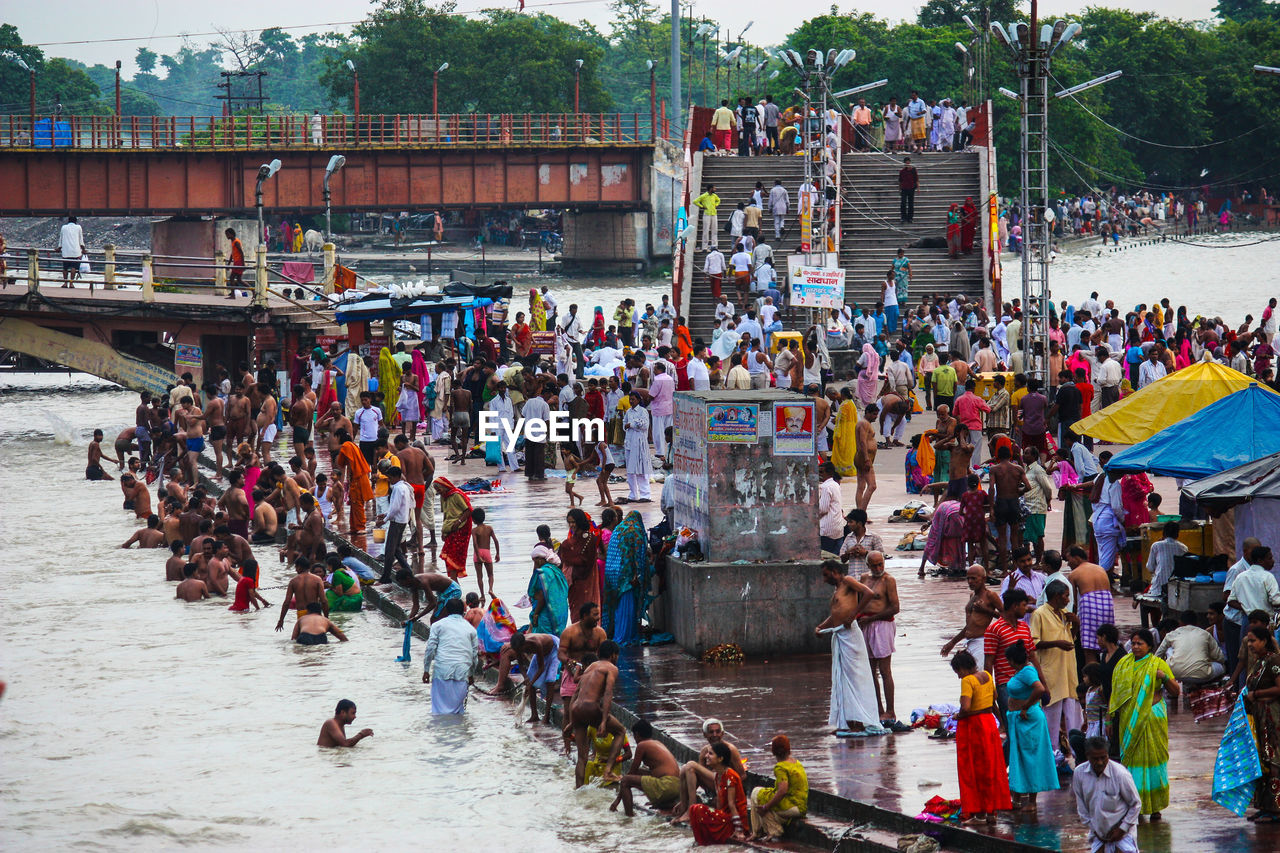 HIGH ANGLE VIEW OF PEOPLE ON BOATS AT RIVER