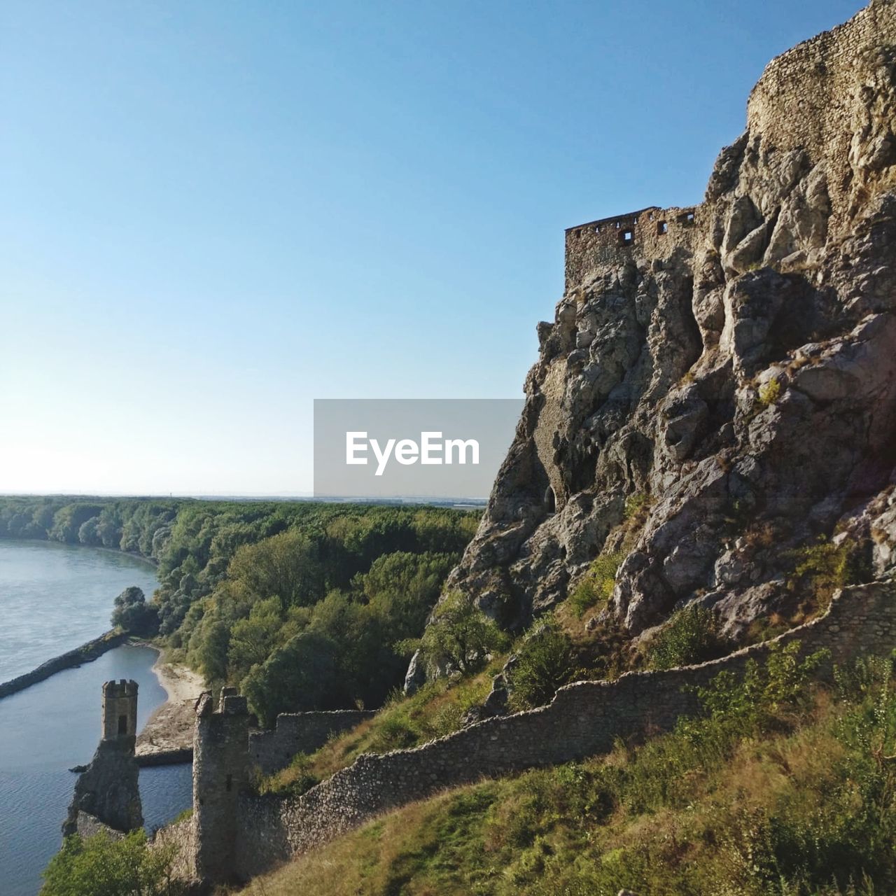 Scenic view of river by mountain against clear sky