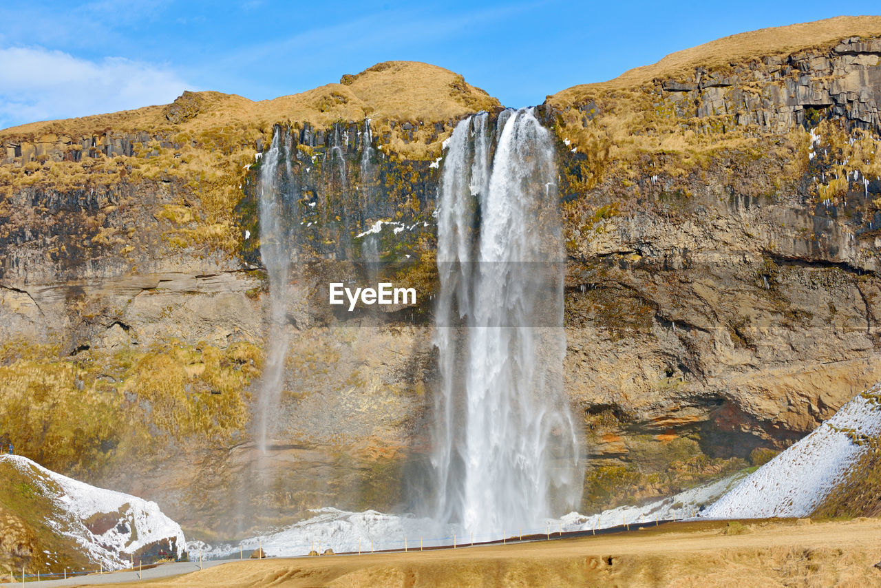 SCENIC VIEW OF WATERFALL AGAINST ROCK