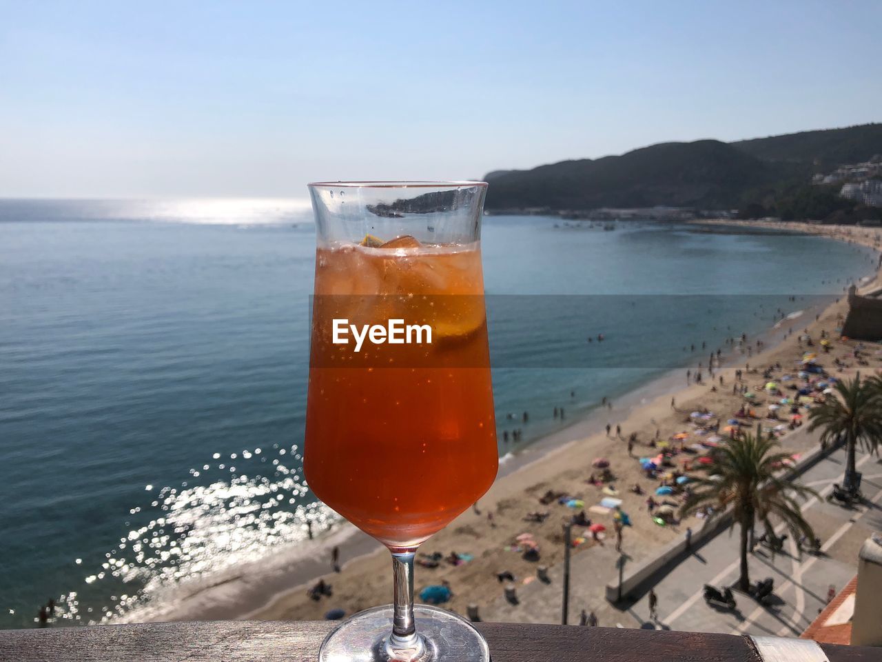 CLOSE-UP OF DRINK ON TABLE AT BEACH