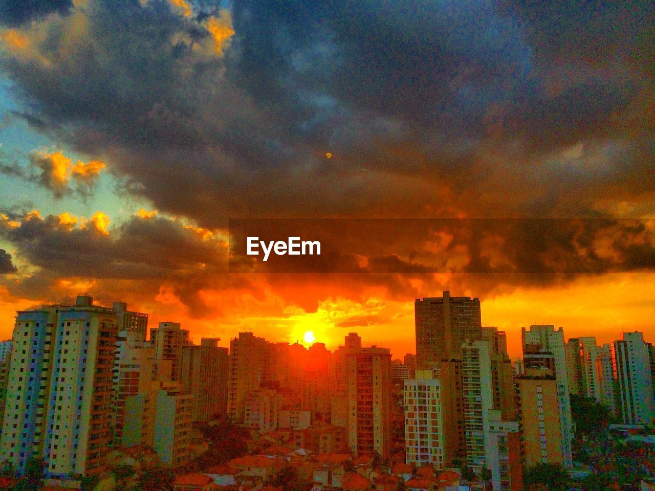 View of cityscape against cloudy sky at sunset