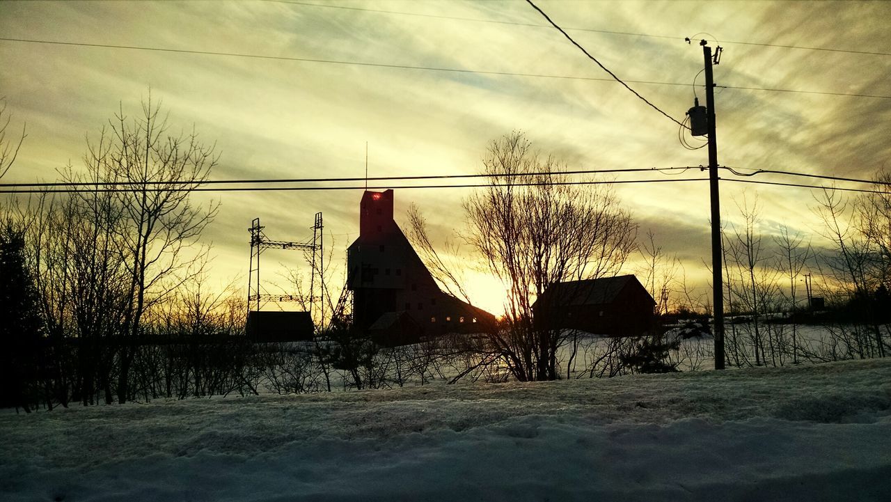 SILHOUETTE OF ELECTRICITY PYLON AGAINST SKY