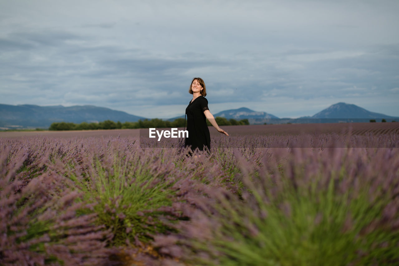 Woman standing on field against sky