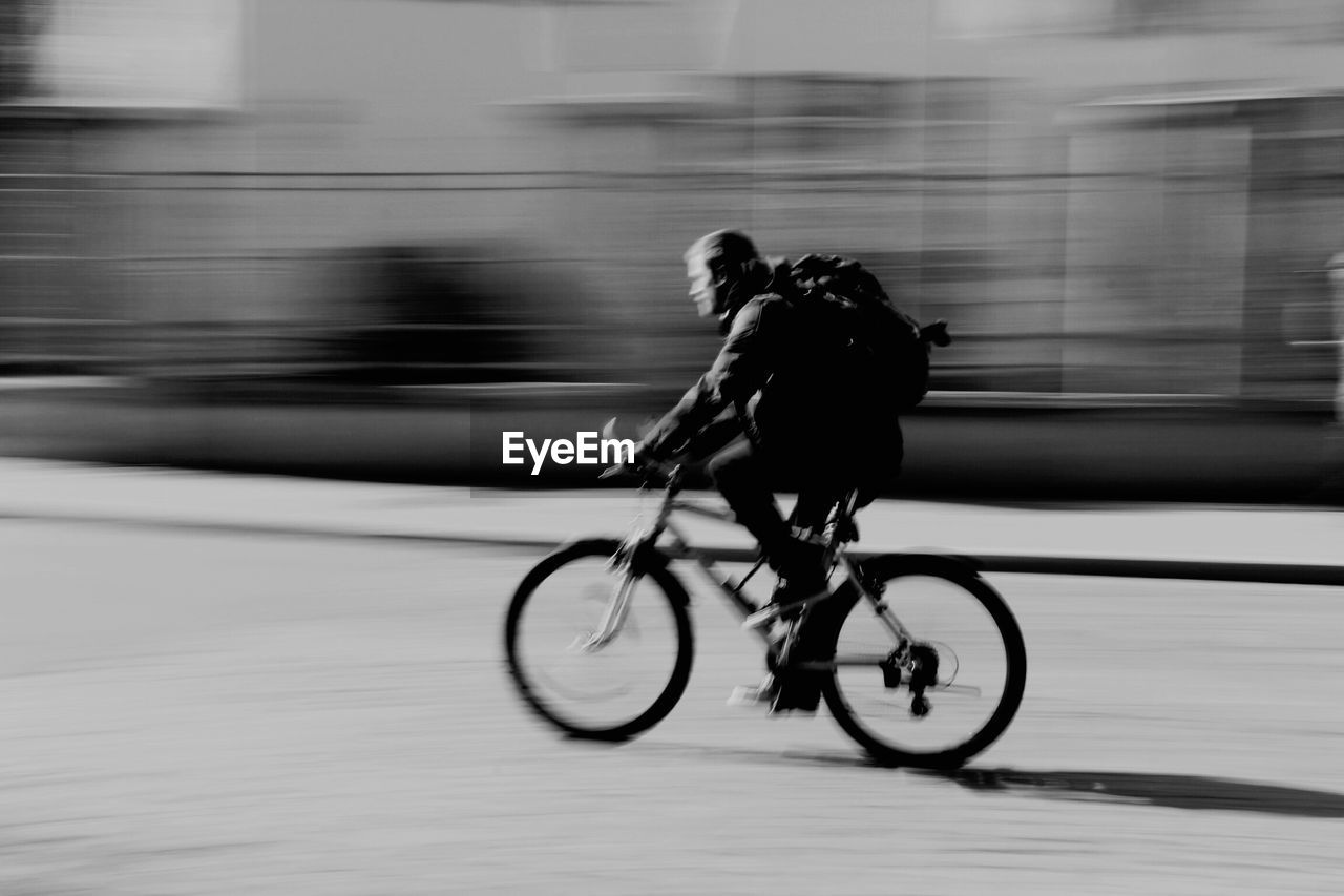 Close-up of silhouette man on bicycle on street